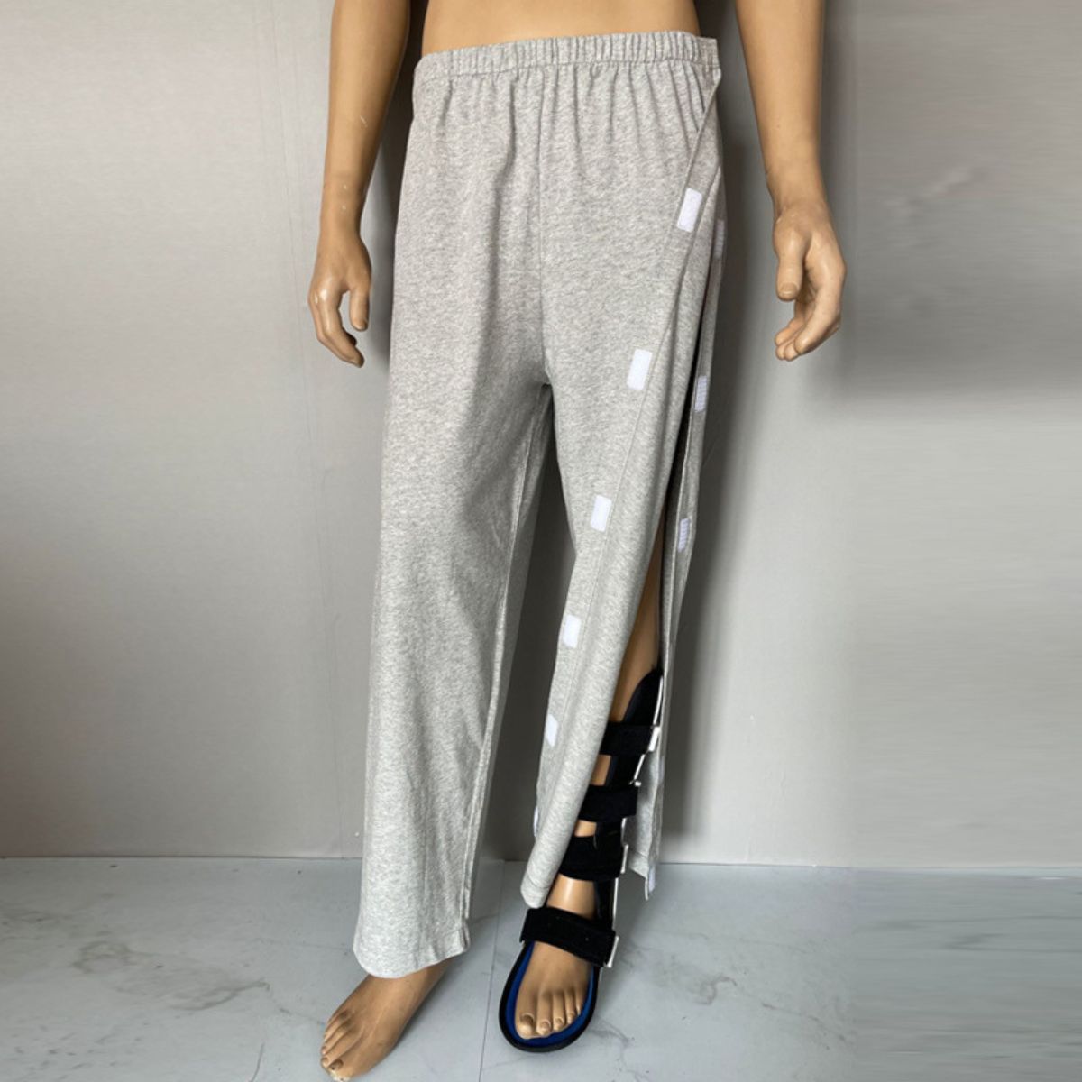 Grey adaptive pants for men with a comfortable elastic waistband, Velcro closure, shown on a standing mannequin