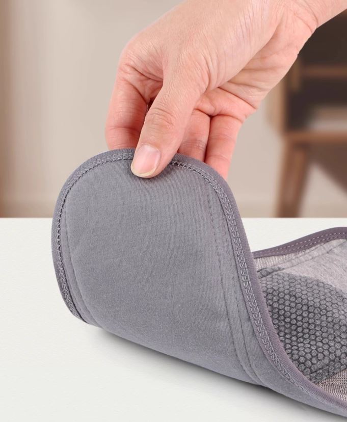 Washable incontinence pad folded to show leak-proof performance, one side wet, other side completely dry, demonstrating the waterproof barrier layer NZ