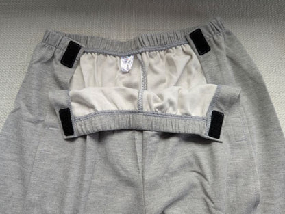 Light grey unisex tear-away pants opened at the waist showing full side Velcro fastening