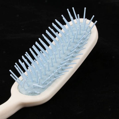 Close-up of long handle hair brush with flexible silicone bristles and rounded tips