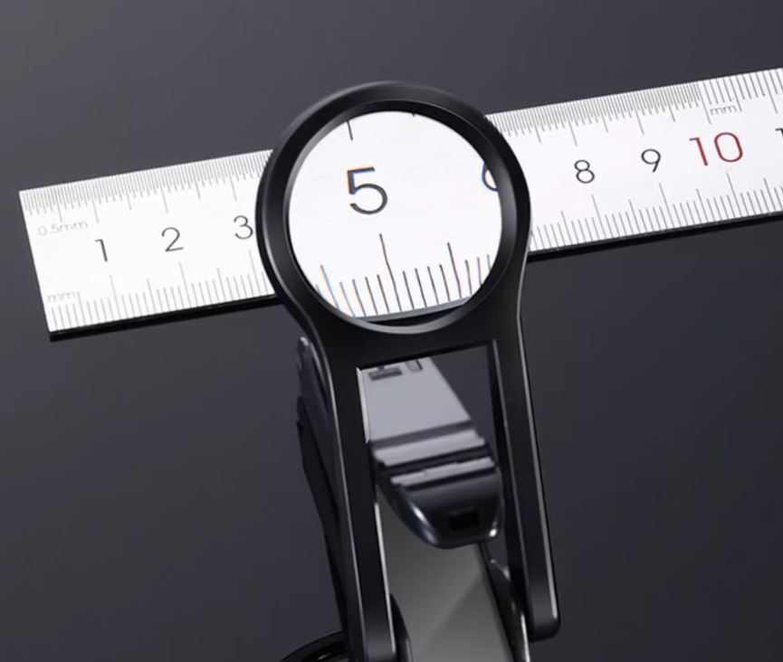 Close-up view through the nail clipper magnifying lens showing enlarged ruler markings