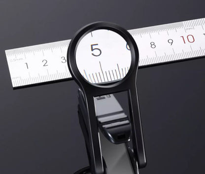 Close-up view through the nail clipper magnifying lens showing enlarged ruler markings